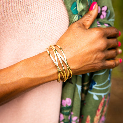 Ira bangle in gold shown on model, shiny finish, adjustable bangle, easy to wear